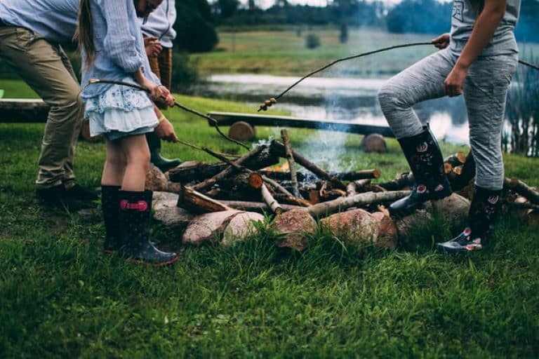 Kids roasting marshmallows with boots on