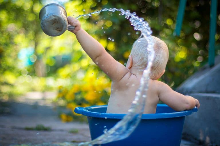 Camping with toddler hack child washing in blue bucket