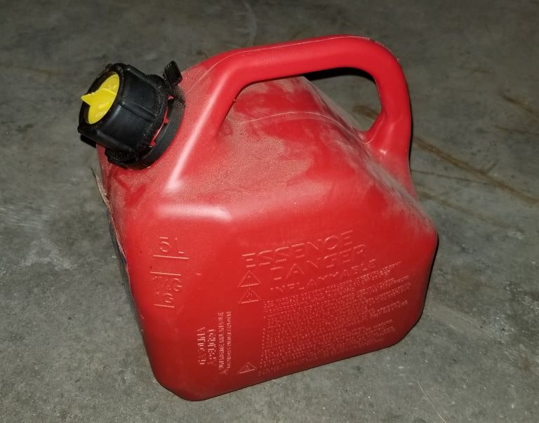 red can of gas on concrete floor