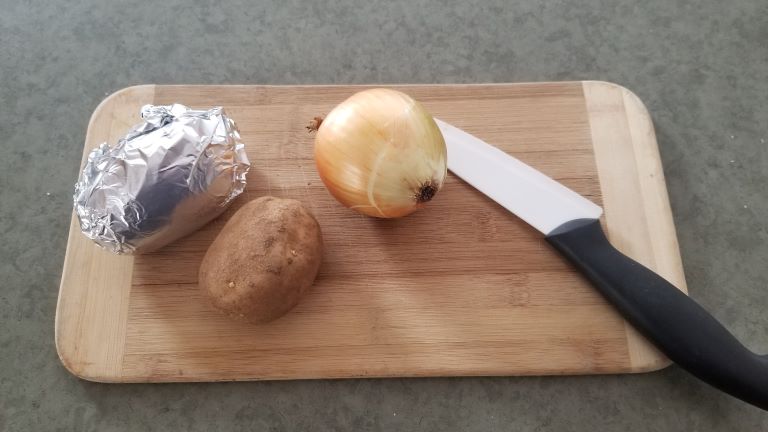 camping meal prep. Onion and potato on cutting board
