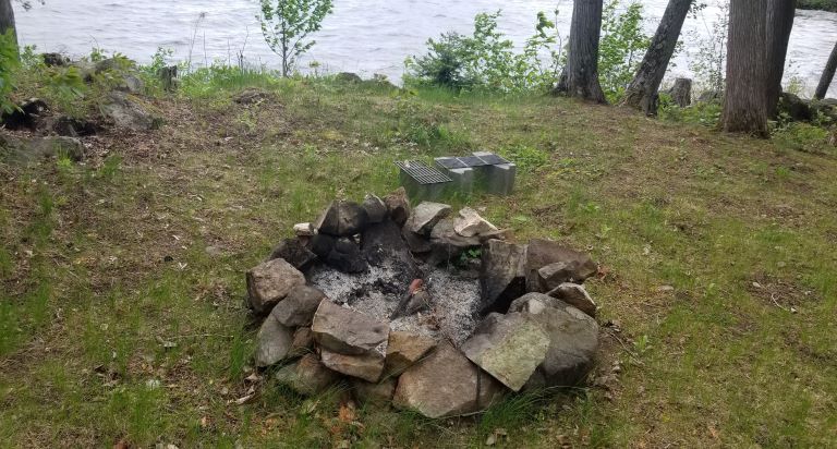 A camping fire pit with grilling grates for cooking.