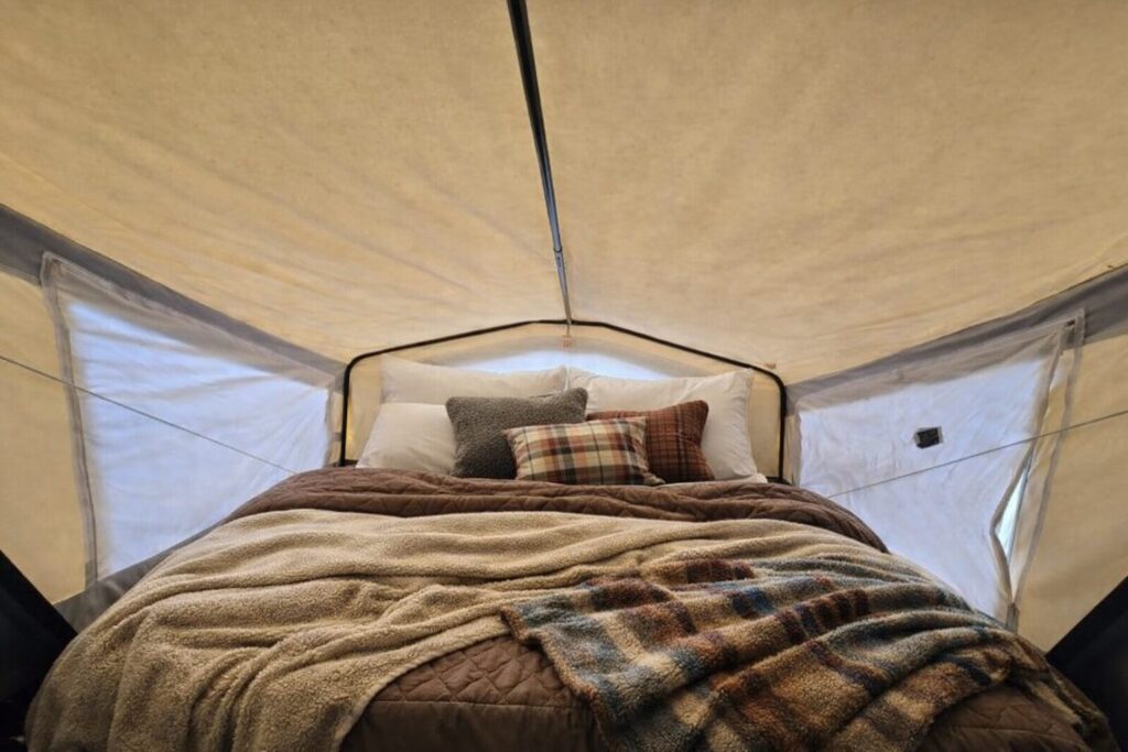 An RV bed setup with plaid blankets and pillows