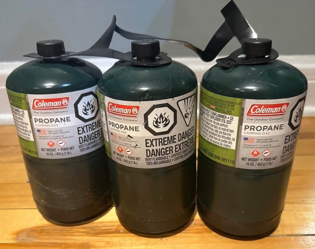 three coleman 1 pound propane cylinders on a table