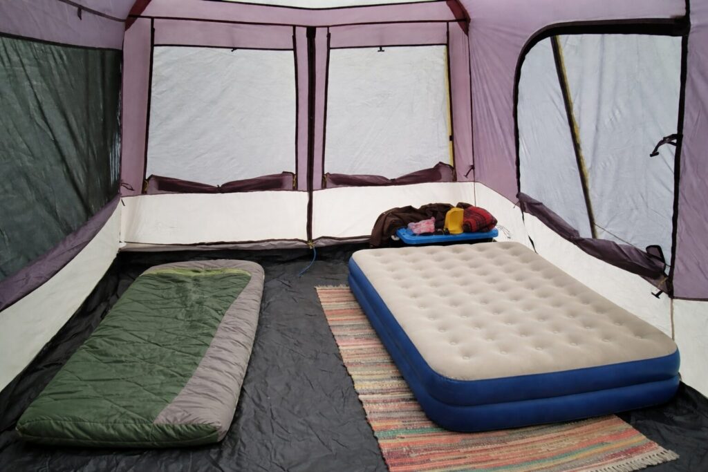 A large cabin tent with an air mattress and sleeping bag.