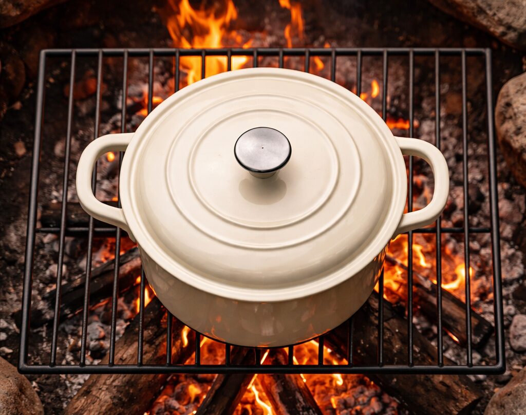 Beige enamel dutch oven on campfire